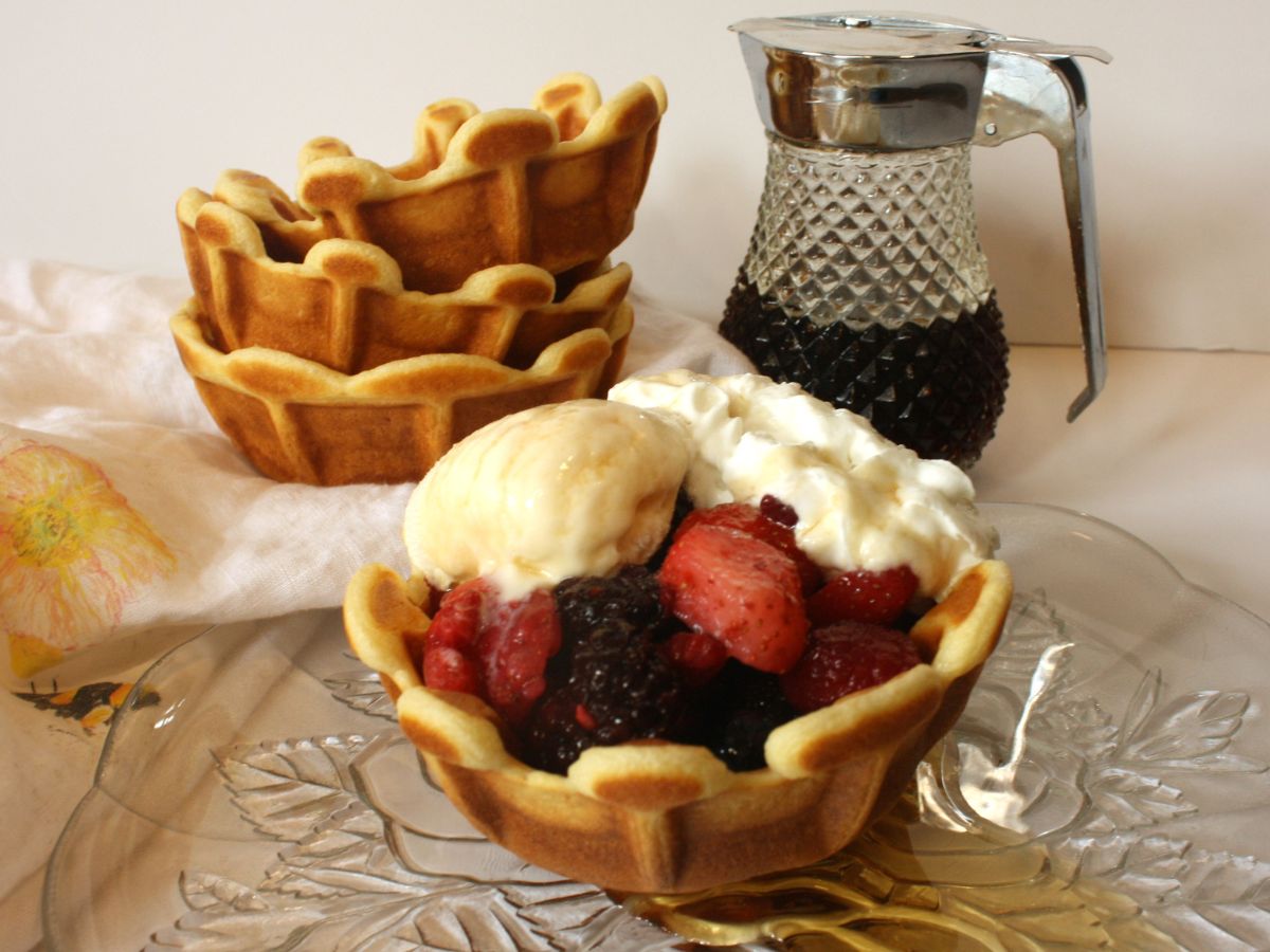 filled waffle on plate with syrup and waffle bowls