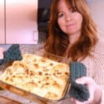 woman holding a dish of baked cauliflower cheese