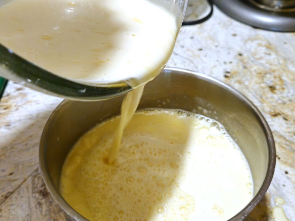 pouring banana custard from a bowl back into a saucepan