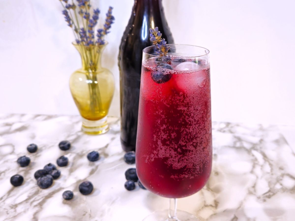 a glass of sparkling lavender blueberry cordial