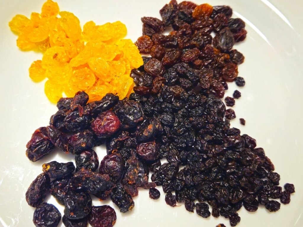 a selection of dried fruit that includes currants, raisins and cranberries