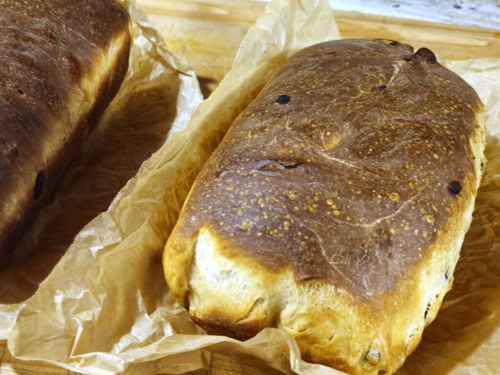 cinnamon fruit bread fresh out of the oven sat on parchment paper