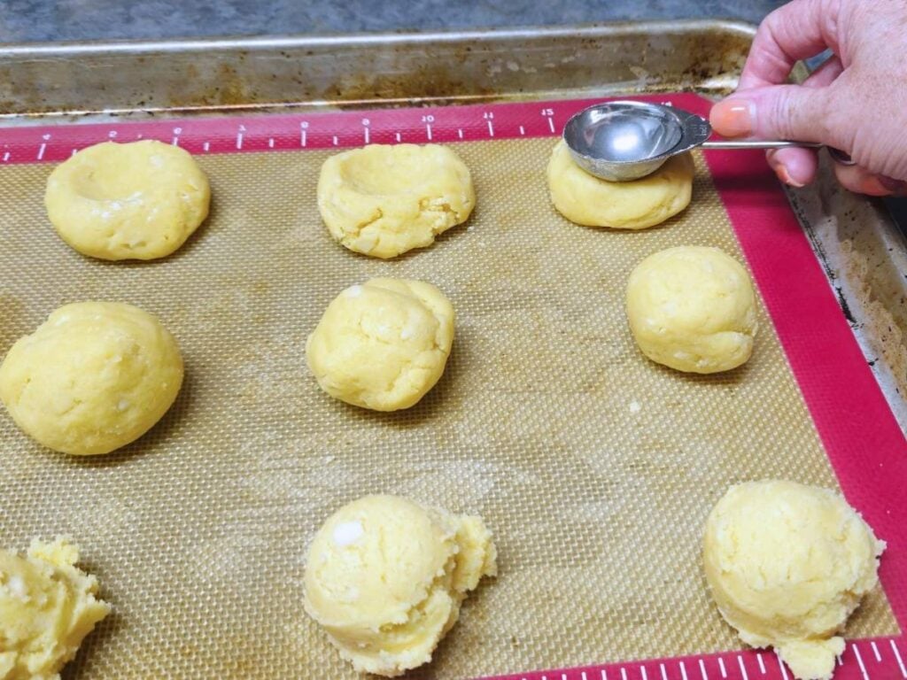 using a table spoon to make a divot in dough