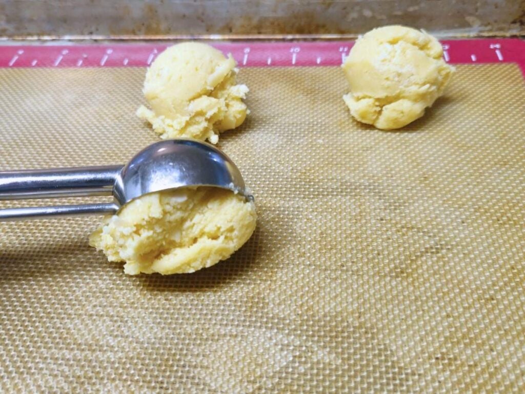 spooning almond melting moment dough onto a baking sheet